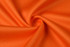 An orange fabric displayed in a swirling pattern, showcasing its smooth texture.