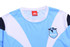 A light blue and white mini waffle tee featuring a logo, with dark blue accents on the sleeves.