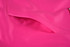 A close-up of a vibrant pink fabric with a smooth texture and visible stitching details.