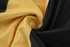A close-up of fabric featuring a swirl of black and gold colours, highlighting a soft texture.