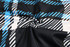 A fabric featuring a blue, black, and white checkered pattern in a swirling arrangement.