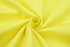A close-up of bright yellow fabric, showcasing the texture and smoothness of the textile.