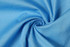 A swirl of light blue cotton fabric, featuring a smooth texture and light sheen.