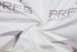 A swirl of white fabric featuring a subtle logo pattern. The texture appears soft and smooth.