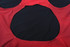 A red women's swimming one-piece with a circular cutout at the back, featuring a logo.