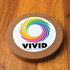 A round cork wireless charger featuring a colorful spiral design and a logo on a white background.