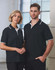 A unisex black polo shirt featuring white detailing, modelled by a man and woman in an indoor setting.