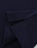 A close-up of a navy blue cotton stretch polo shirt, showcasing the fabric and folded sleeves. It features a logo.