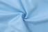 Light blue fabric with a smooth texture, displaying a spiral pattern in the centre. It has a logo.
