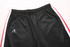Black training pants with red side stripes and an emblem on the left side. Features an elastic waistband.