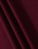 A close-up of maroon fabric, showing a textured weave with draped folds.