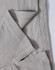 A close-up of a light grey polo shirt, showing the textured fabric and stitching details. The shirt features a logo.