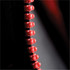 A close-up of a red zipper with toggles on a dark fabric background, featuring a visible logo on the garment.