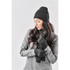 A knit beanie in black, styled with matching gloves and a long scarf, set against a neutral background.