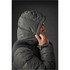 A grey hooded parka jacket with quilted detailing, displayed on a model's profile against a dark background.