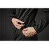 A woman adjusting the waist of a black softshell jacket featuring a drawstring detail. The jacket has a sleek design.