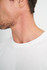 A white men's t-shirt displayed on a model, focusing on the neckline and shoulder area.
