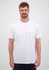 A man wearing a plain white short sleeve tee, standing against a neutral background. The tee features a logo.