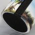 A drink bottle holder featuring a colourful tropical design with palm trees and a black textured base.
