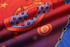 A HAND TOWEL features vibrant patterns in red, purple, and orange, with decorative motifs and a logo.