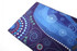 A spread towel featuring vibrant blues and purple patterns, decorated with dot motifs and swirls. It has a logo.