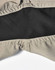 A close-up of beige work shorts featuring a black inner lining and stitched seams, with a logo visible.