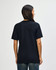 A black Gildan Softstyle adult t-shirt, featuring a simple design and a logo on the back. The model is facing away.