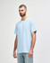 A softstyle adult t-shirt in light blue displayed on a model, featuring a round neck and short sleeves. It has a logo.