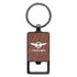 A rectangular keychain with a wood-like texture and a metal keyring. It features a logo on the front.