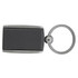 A carbon fibre keychain in black with a silver ring and a sleek design. It features a logo on one side.