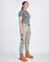 Unisex cotton stretch drill cuffed work pants in khaki, paired with a grey polo and tan work boots. Features pockets and an elastic waistband.