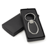 A sleek silver keychain with an oval design, presented in a black box.