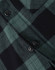 A close-up of a black and green flannel plaid shirt featuring button details. The shirt has a classic check pattern.