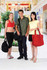 A black tote bag and a red tote bag are held by two models, while a man carries a black messenger bag.