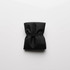 A folded black reusable grocery bag secured with an elastic band, featuring subtle texture and a minimal design.