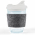 A reusable coffee cup with a clear body, snap lid, and a gray RPET band for grip.