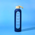 A drink bottle in navy blue with a cream lid and a carrying strap. It features a branded logo and time markers.