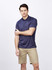 A navy blue men's polo shirt displayed on a model, featuring a logo and styled with beige shorts.