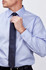 A light blue men's long sleeve button-up shirt with a polished look, paired with a navy tie. Features a logo.