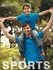 A man and a boy wear matching blue polo shirts, with the boy sitting on the man's shoulders in an outdoor setting.