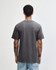 A unisex short sleeve T-shirt in grey, featuring a simple design and visible branding on the back.