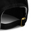 A black cap featuring a metal fastening at the back, showcasing its stitching and material detail.