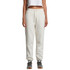 Cream track pants with an elastic waistband displayed on a model, featuring a logo.
