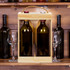 A wooden wine crate in natural finish holds two wine bottles with a rope handle, surrounded by glasses and other bottles.