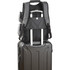A grey backpack with multiple compartments sits atop a black suitcase, featuring a pull handle. It has visible branding.