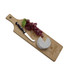A wooden serving board with a cheese wedge, grapes, and a knife, featuring a logo.