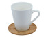 A white ceramic mug with a handle, sitting on a round bamboo saucer. The mug has a smooth, glossy finish.