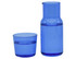 A blue glass carafe next to a matching tumbler, both filled with water. The carafe features a sleek, modern design.