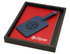 A red journal and a blue luggage tag in a black box, featuring a logo on the tag and journal cover.