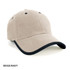 A beige cap with a navy peak and a logo on the front, featuring a wrap-over design.